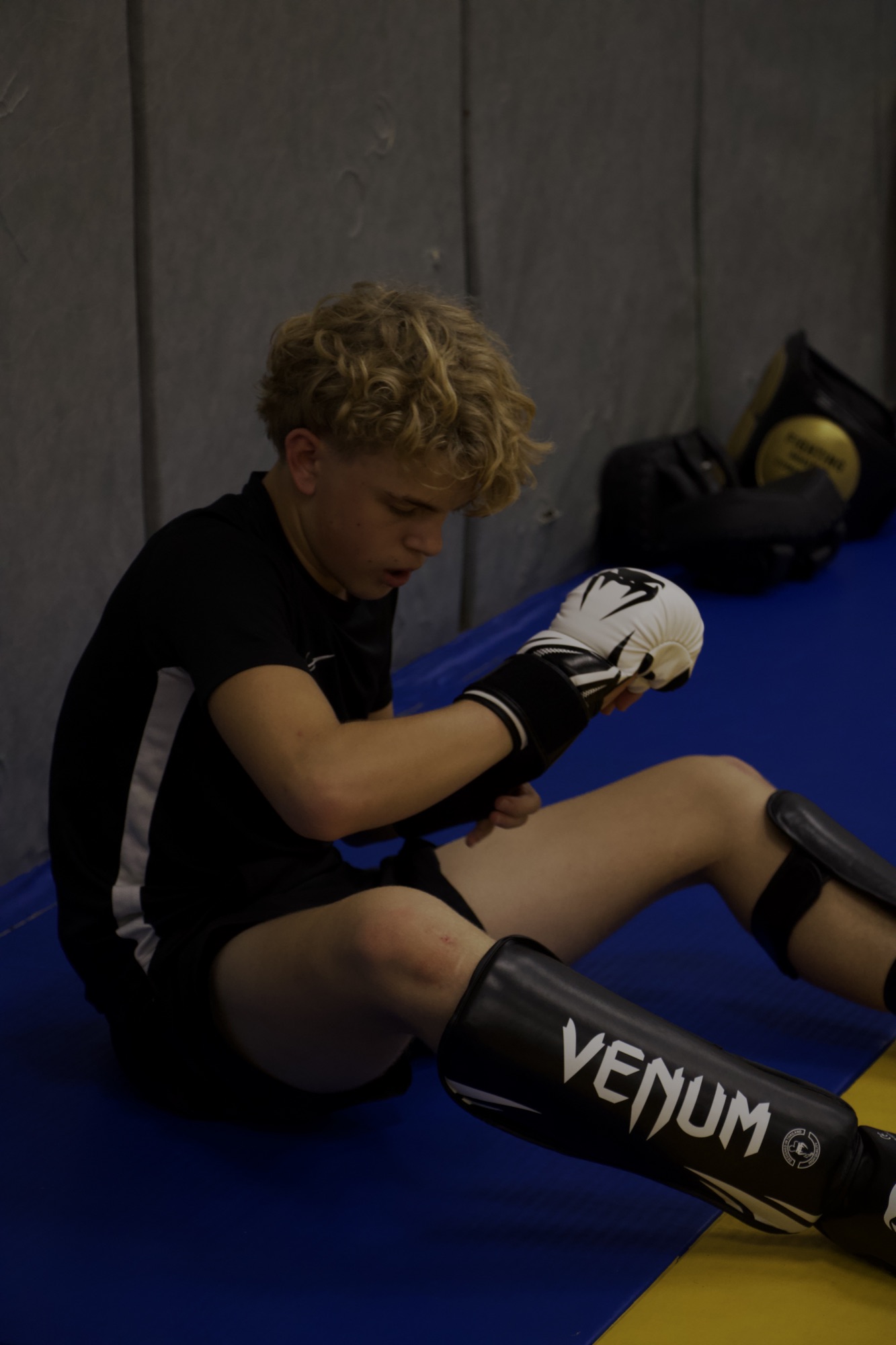 Un jeune pratiquant ajuste ses gants et ses protections